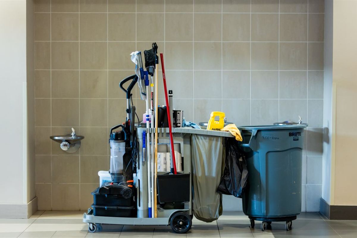 Janitorial cart stocked with cleaning tools and supplies in a commercial building