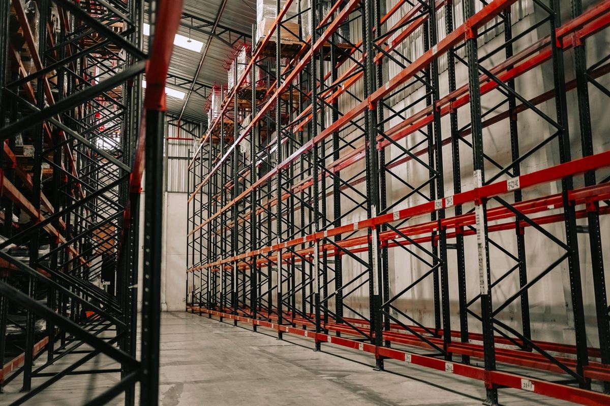 Warehouse aisle with tall metal storage racks and a clean floor