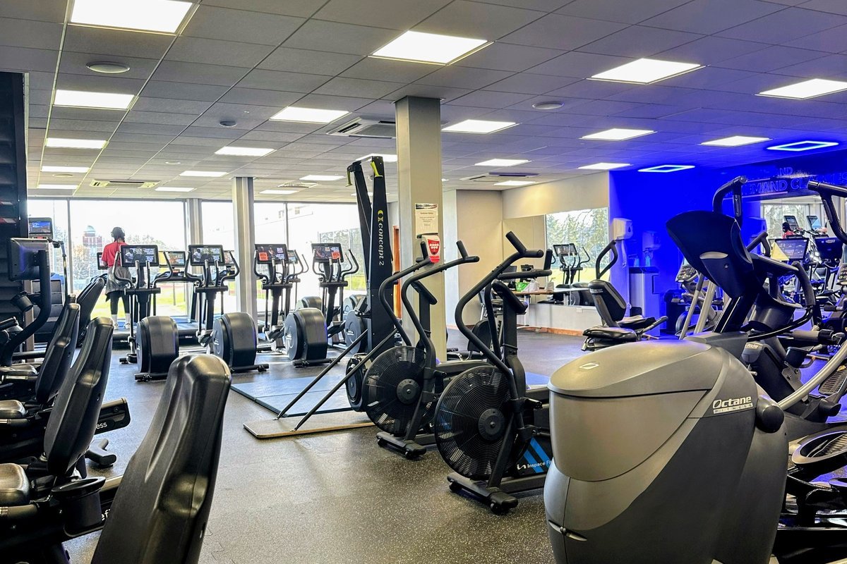 Gym cleaning professional disinfecting exercise equipment in a Charlotte NC fitness center