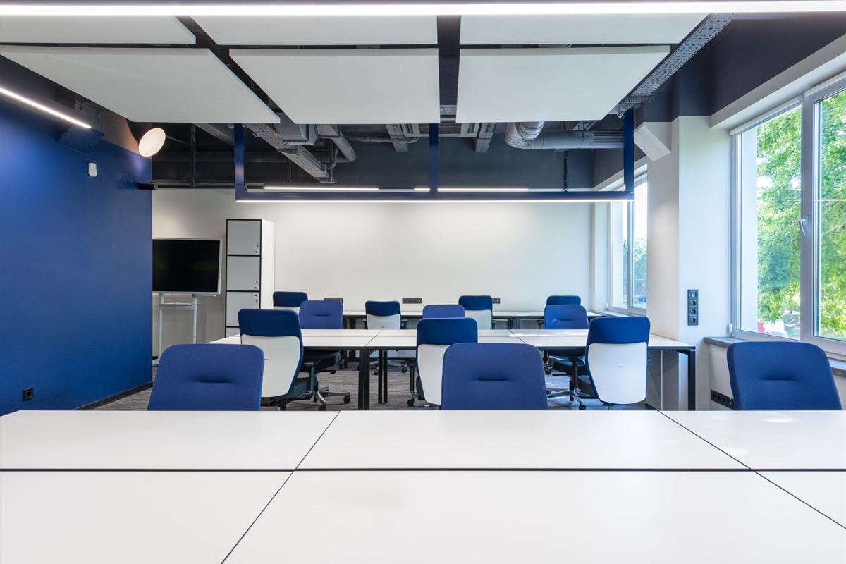Clean, modern office workspace with desks and chairs ready for the next workday