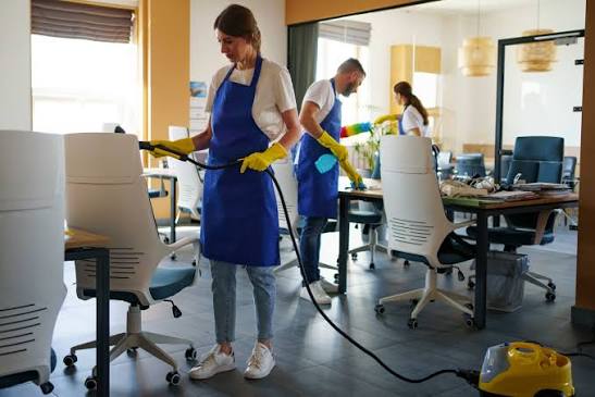 Professional office cleaning team disinfecting desks and chairs in Charlotte